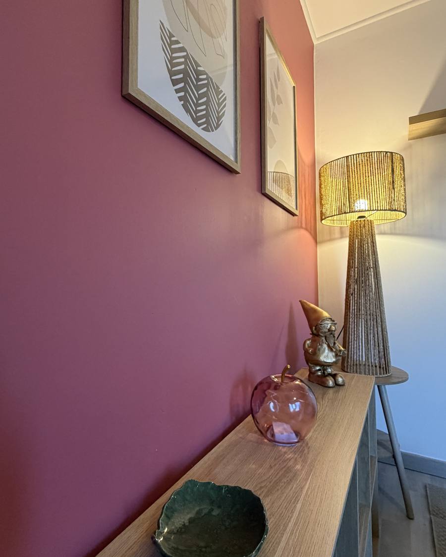 Détail du cabinet : console en bois, pomme en verre rose et lampe en corde